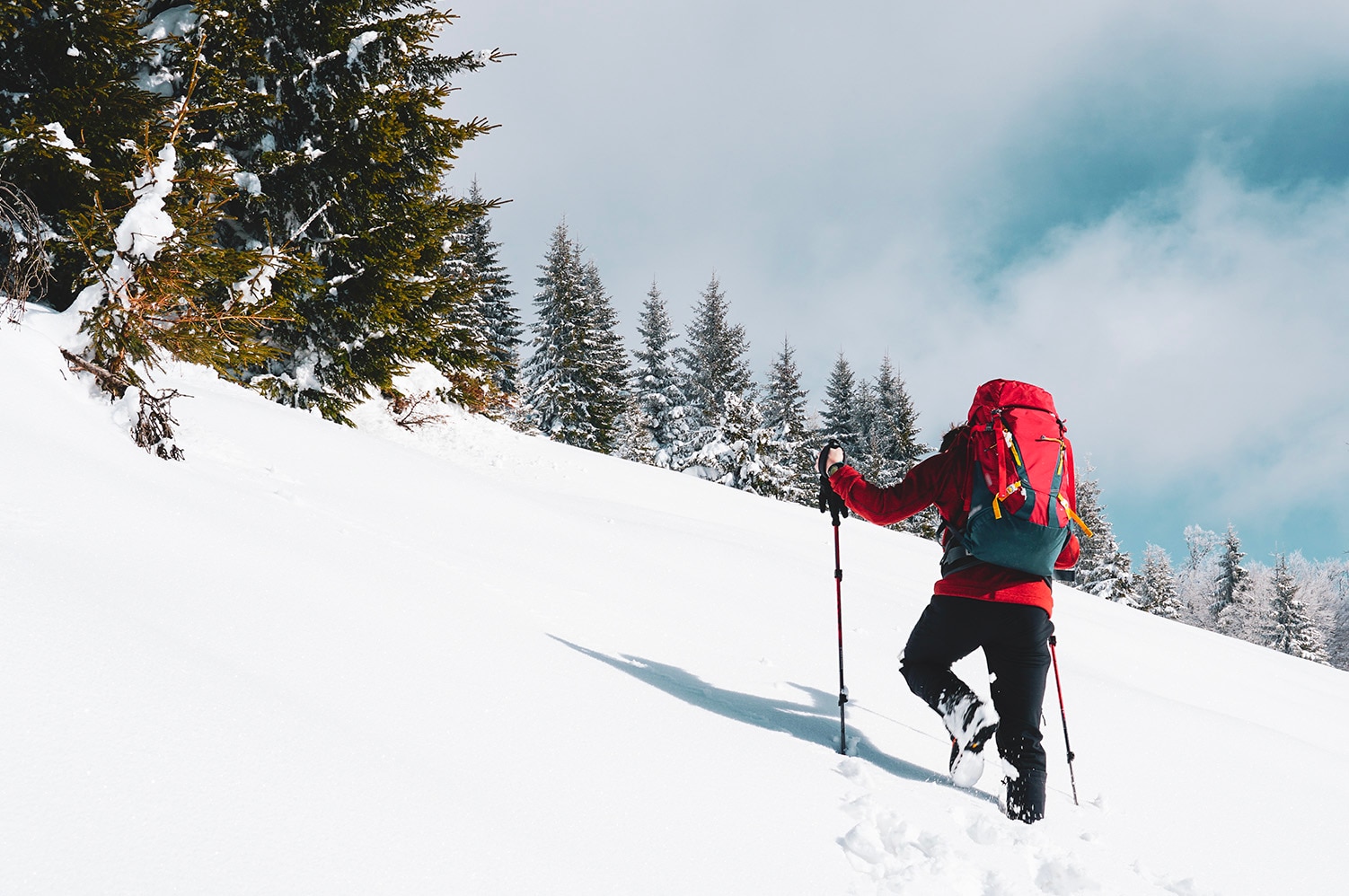 beautiful-shot-male-hiker-with-red-travel-backpack-hiking-up-snowy-mountain-winter